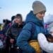 Молода дівчина з України чекає зі своєю матір'ю та собакою після перетину кордону з Польщею у 2022 році. Фото: PA